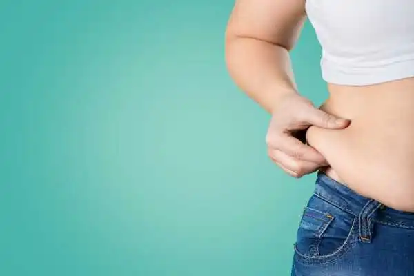 Image of woman pinching her love handles to show weight gain Bedford
